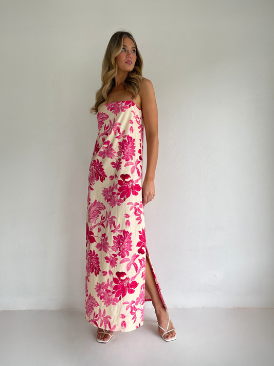 By Nicola Ivy maxi dress in pink floral print with column silhouette, straight neckline and side split, perfect for weddings and summer events.