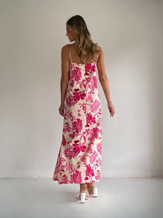 By Nicola Ivy maxi dress in pink floral print with column silhouette, straight neckline and side split, perfect for weddings and summer events.