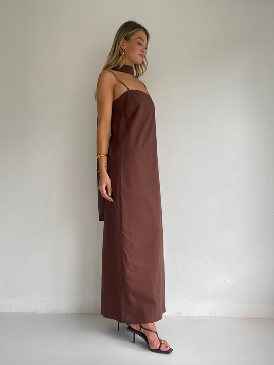 By Nicola Ivy maxi dress in chocolate brown cotton-linen with straight neckline, side slit, column style and chiffon neck tie, ideal for weddings and summer events.