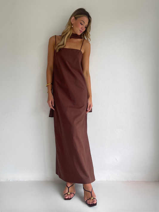 By Nicola Ivy maxi dress in chocolate brown cotton-linen with straight neckline, side slit, column style and chiffon neck tie, ideal for weddings and summer events.