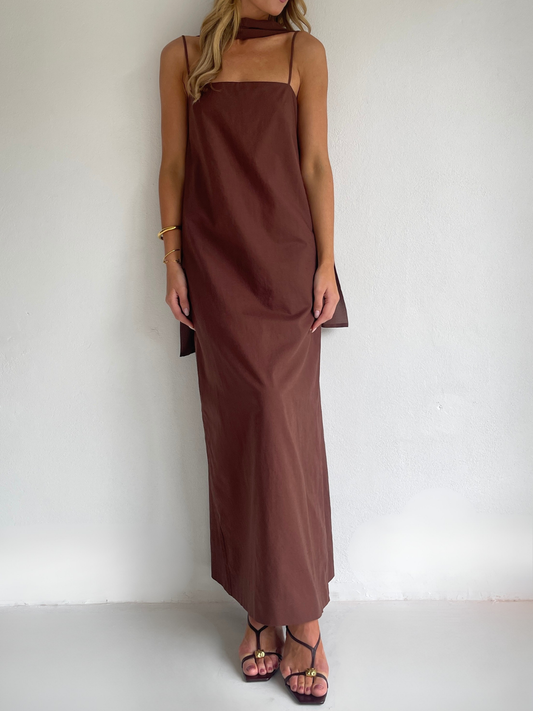 By Nicola Ivy maxi dress in chocolate brown cotton-linen with straight neckline, side slit, column style and chiffon neck tie, ideal for weddings and summer events.